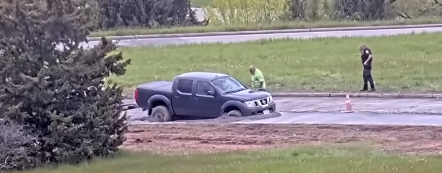 [IMG: a wide view of the vehicle stuck, with workers in frame