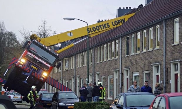[IMG: Crane toppled over on roof]